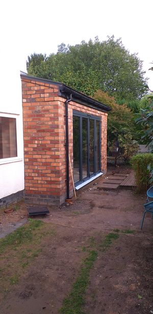 Finished extension built with reclaimed bricks and pitched slate roof
